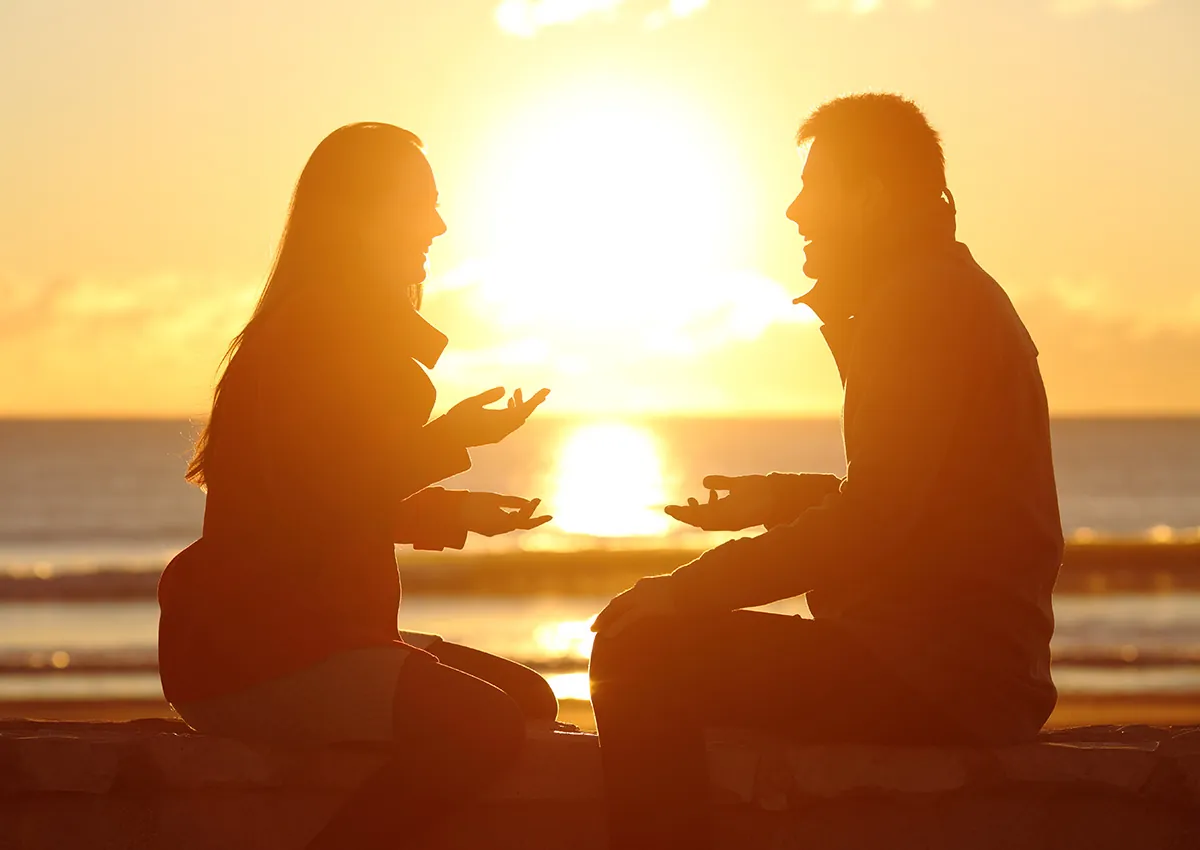 Two people in a relaxed conversation at sunset